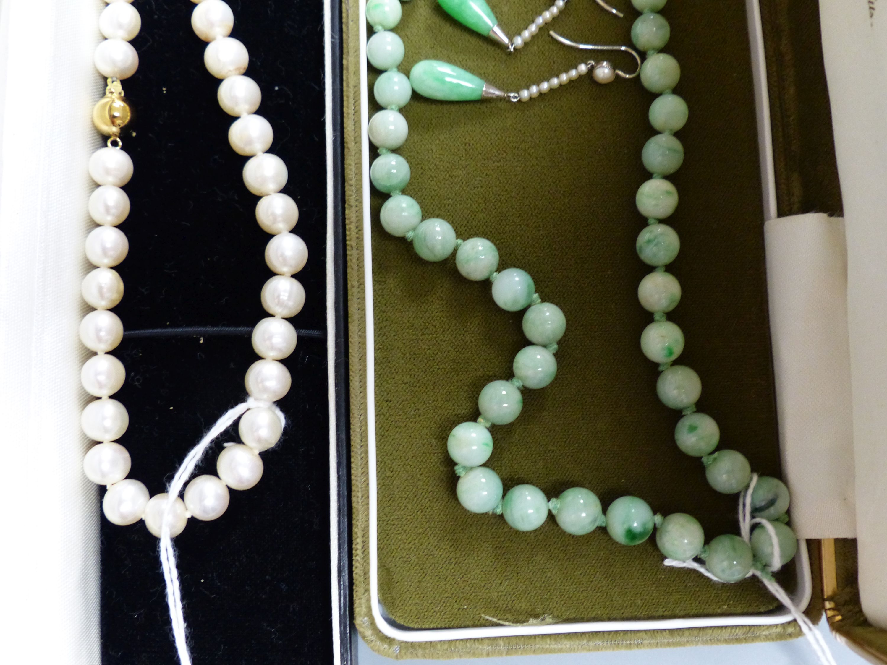 A single row uniform cultured pearl necklace with 9ct gold ball clasp, a graduated jade bead necklace and a pair of jade and seed pearl drop earrings, 37mm